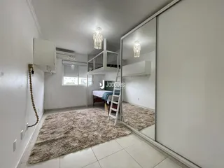 Quarto com cama e espelho refletindo o ambiente interno.