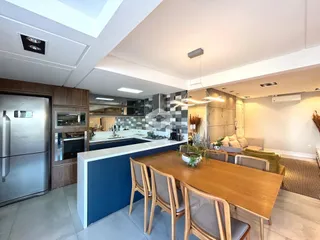 Uma cozinha moderna com ilha azul e mesa de jantar de madeira.