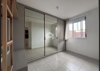 Interior com piso de cerâmica e portas de vidro deslizando em um imóvel.