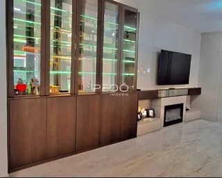 Sala de estar com armários de madeira e lareira em um imóvel.