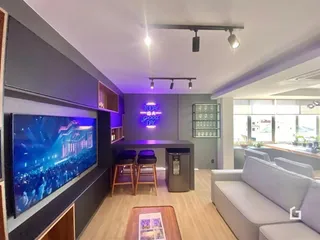 Sala de estar moderna com televisão grande e decoração contemporânea.