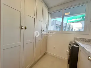 Hall de entrada com armários embutidos brancos.
