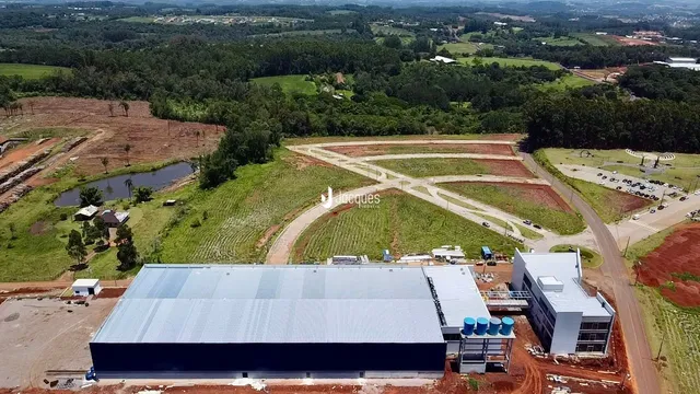 Vista aérea de uma área de terra com campos e um grande edifício no centro.