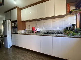Foto de uma cozinha moderna com armários brancos e bancada de granito.