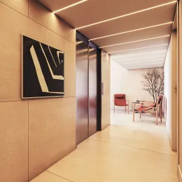 Corredor interno com paredes claras e iluminação embutida.