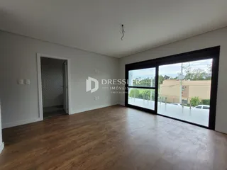 Sala de estar com piso de madeira e porta de vidro.