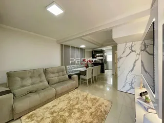 Sala de estar e jantar com sofá e mesa de jantar em um imóvel no Brasil.