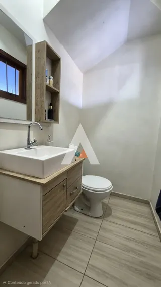 Foto de um banheiro com bancada de madeira e vaso sanitário.