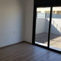 Foto de um ambiente interno com piso de madeira e grandes janelas.