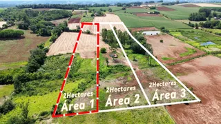 Vista aérea de uma propriedade rural em Lajeado, Brasil, mostrando áreas de terra e vegetação.
