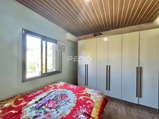 Quarto com janela e armário branco em Lajeado.