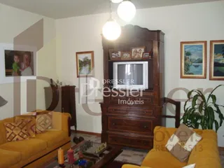Sala de estar com sofá e móveis de madeira em uma residência.