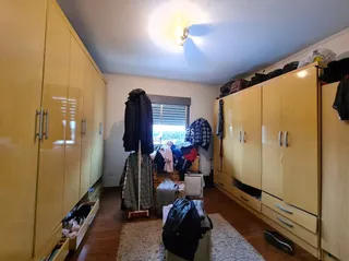 Quartos com armários em tom amarelo claro e piso de madeira.