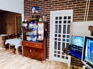 Interior de uma sala com paredes de tijolo aparente e móveis de madeira.