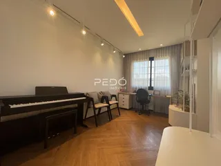 Sala de estar com piano e piso de madeira clara.
