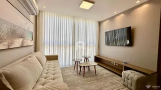Sala de estar com sofá e televisão em um ambiente claro.