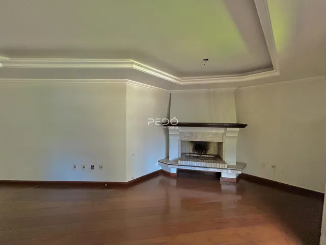 Interior de uma sala com piso de madeira e lareira em Lajeado, Brasil.