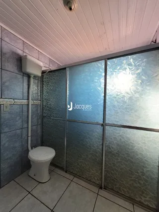 Foto de um banheiro interno com azulejos e divisória de vidro.
