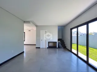Corredor interno com piso de cerâmica e grandes janelas.