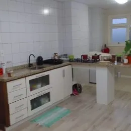 Foto de uma cozinha interna com armários brancos e piso de madeira clara.