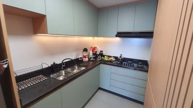 Vista interna de uma cozinha moderna com armários em tom verde claro.