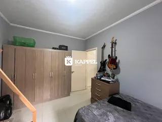 Um quarto com armário de madeira e instrumentos musicais pendurados.