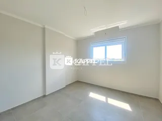 Ambiente interno com paredes brancas e piso claro iluminado por luz natural.