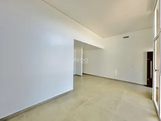 Corredor interno com paredes brancas e piso de cerâmica claro.