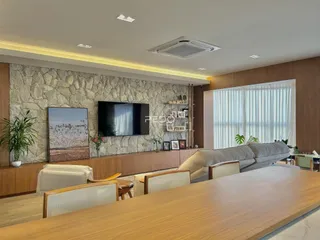 Sala de estar com parede de pedra e decoração moderna em imóvel no Brasil.