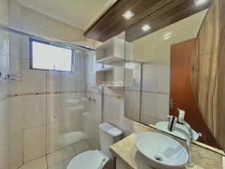 Um banheiro moderno com revestimento cerâmico e bancada de mármore.