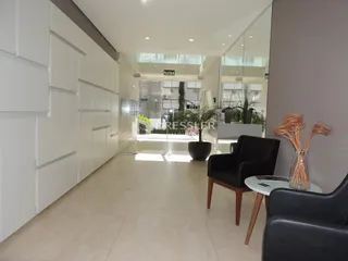 Corredor interno de uma residência com paredes brancas e piso claro.