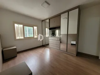 Sala de estar com piso de madeira e armários espelhados.