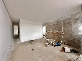 Foto de um interior de construção com paredes de concreto aparente.