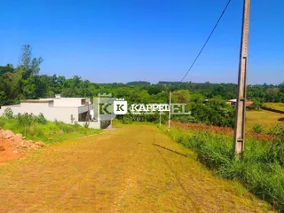 Vista externa de um terreno aberto com vegetação seca e grama.