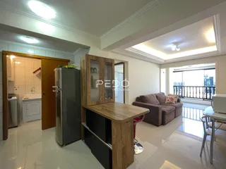 Ambiente interno de uma sala com armário e geladeira em um imóvel no Brasil.