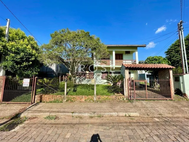 Fachada de uma casa em Lajeado, Brasil, com cerca e vegetação ao redor.