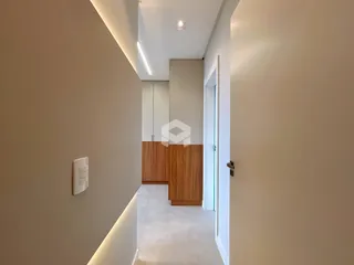 Corredor interno de um apartamento moderno com paredes claras e piso claro.