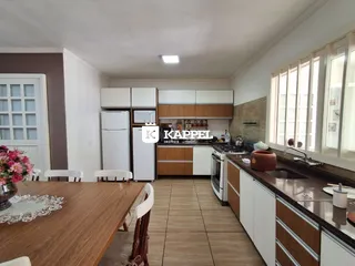 Cozinha moderna com armários brancos e bancada de granito.
