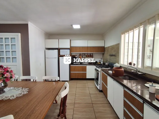 Cozinha moderna com armários brancos e bancada de granito.
