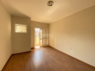 Foto de uma sala com piso de madeira e parede clara.