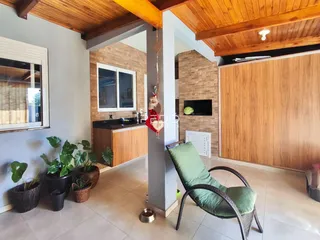 Ambiente interno de uma sala de estar com piso de cerâmica e detalhes em madeira.