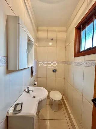 Foto de um banheiro com revestimento cerâmico branco.