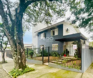 Fachada de uma casa em Lajeado, Brasil, com cerca e jardim na frente.