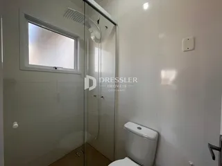 Foto de um banheiro com box de vidro e piso de cerâmica.