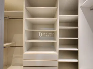 Detalhe de um sistema de estantes e armários brancos no interior de uma propriedade.