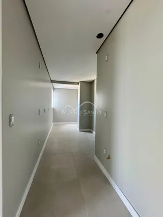 Corredor interno de uma residência com paredes brancas.