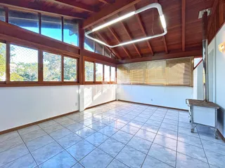 Ambiente interno com piso de cerâmica e teto de madeira em uma residência.