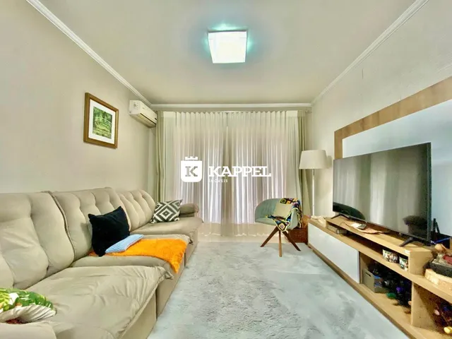 Ambiente interno com sofá e televisão em uma sala de estar.