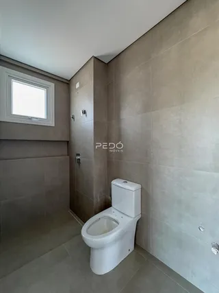 Foto de um banheiro com revestimento de cerâmica neutra.