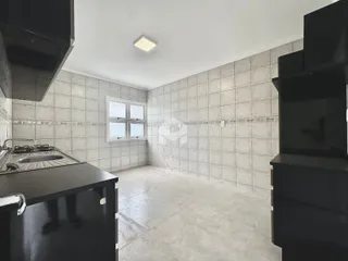 Foto de uma cozinha com paredes de azulejo claro e piso de concreto polido.